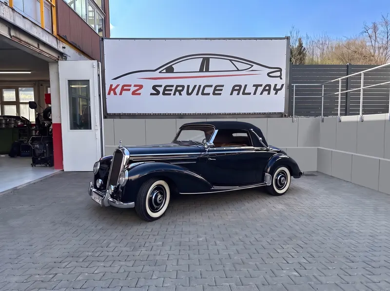 Hof und Einfahrt von Kfz Service Altay mit Werkstatt-Banner, offener Halle und einem Oldtimer