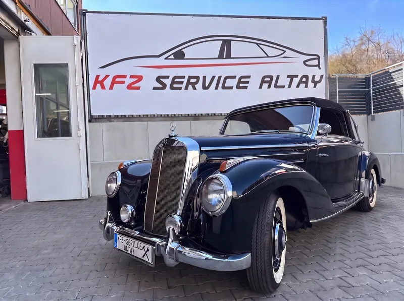 Dunkelblaues Mercedes-Cabriolet aus den 1950er-Jahren vor dem Banner von Kfz Service Altay