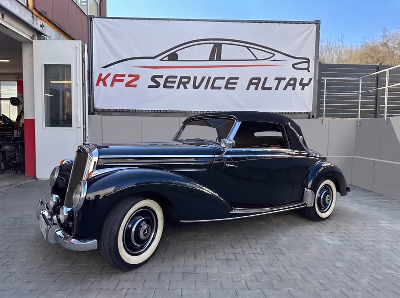 Restauriertes dunkelblaues Mercedes-Cabriolet mit Weißwandreifen im Hof von Kfz Service Altay